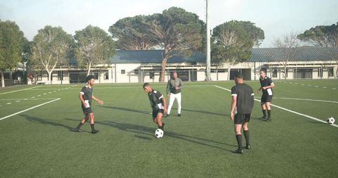 Teen soccer players practicing teamwork on field
