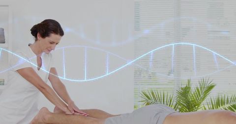 Massage therapist massaging client calves in wellness clinic with dna helix overlay