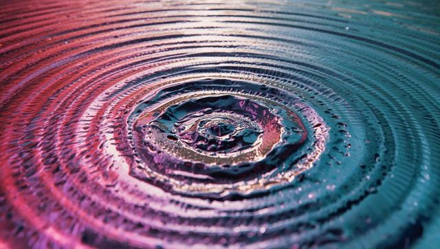 Vibrant concentric water ripples with pink teal shades