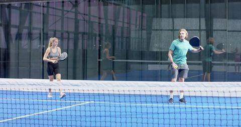 Friends Playing Padel Tennis on Modern Blue Court