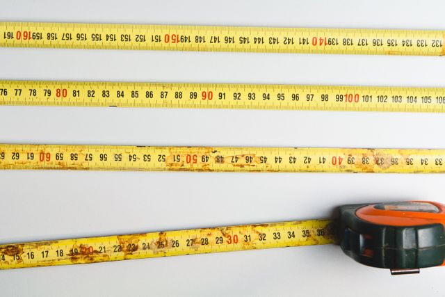 Close up view of measuring tape against grey background. Construction and Repair concept