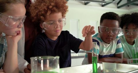 Elementary students conducting green chemistry experiment wearing safety goggles in lab