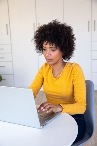 Focused Woman Working at Home Office Nook on Laptop