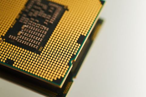 Close-up view of gold-plated computer processor on white background