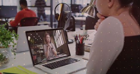 Office worker participating in virtual meeting at modern workspace