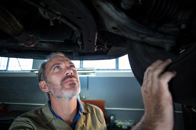 Mechanic examining a car in repair shop