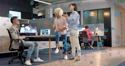 Creative team presenting virtual reality headset prototype in modern open-plan office