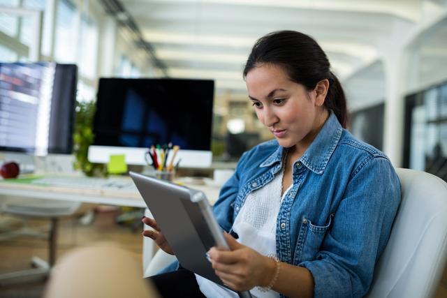 Female graphic designer using digital tablet in office