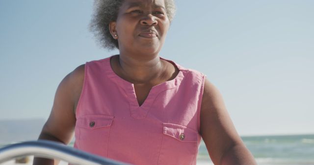 Senior Woman Relaxing at Beach in Pink Blouse Enjoying Sunny Day - Download Free Stock Images Pikwizard.com