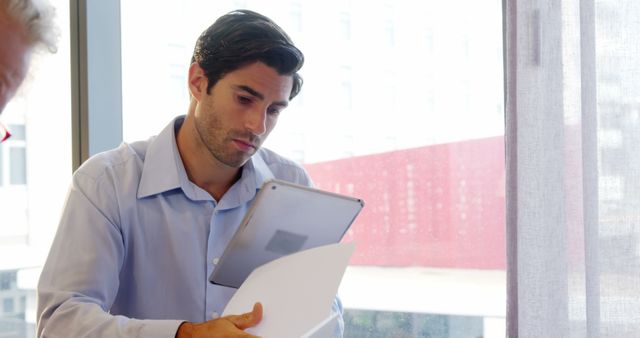 Young Professional Analysing Documents on Tablet - Download Free Stock Images Pikwizard.com