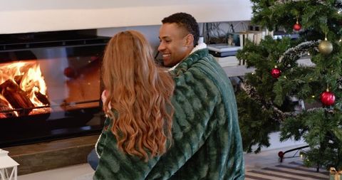 Couple cozy by christmas fireplace matching decor