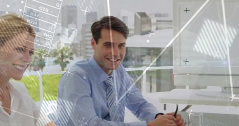 Smiling business professionals analyzing data in high-tech office