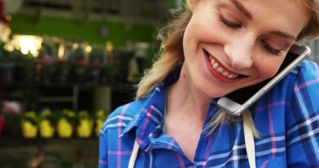 Smiling woman talking on phone in garden center - Download Free Stock Images Pikwizard.com