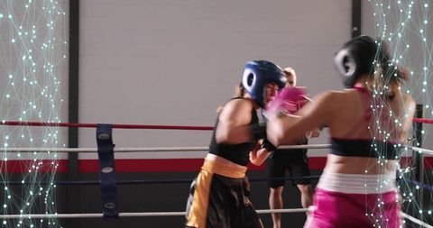 Female Boxers Sparring in Gym Ring Wearing Headgear and Gloves Training with Referee Focus