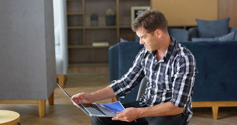 Focused Male Professional Examining Report in Office Lounge