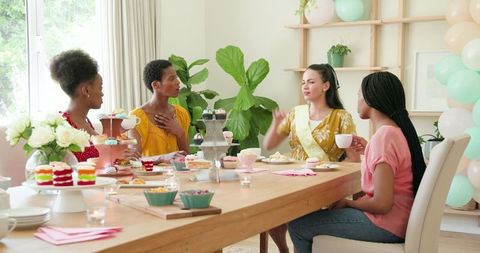 Diverse Women Enjoying Tea and Desserts at Home Gathering