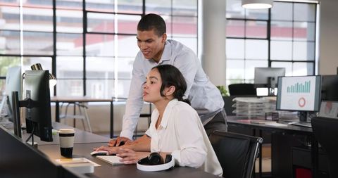 Coworkers Collaborating on Project in Modern Office Environment