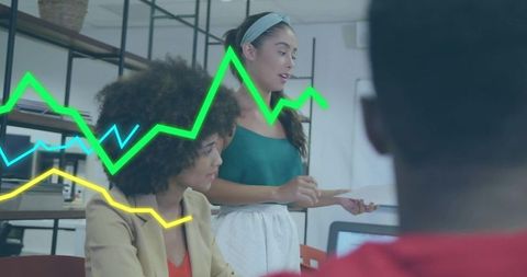 Businesswomen Analyzing Line Graphs in Modern Office