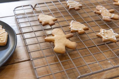Gingerbread cookies cooling on wire rack with icing detail on wooden tabletop baking