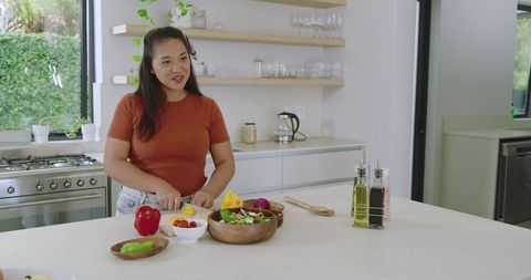 Woman preparing salad in modern kitchen