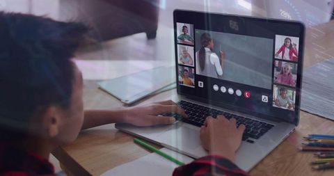 Schoolchild attending online class on laptop at home desk with teacher and classmates