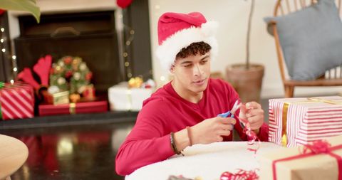 Young Man Preparing Christmas Gifts in Cozy Living Room - Download Free Stock Images Pikwizard.com