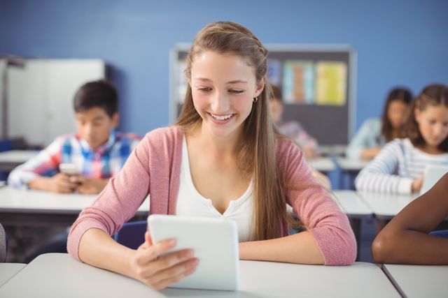Smiling student using a digital tablet in a classroom with other students in the background. Ideal for illustrating modern education, technology in schools, interactive learning environments, and academic settings. Can be used in educational blogs, school websites, and technology in education articles.