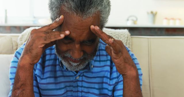 Stressed Senior Man Sitting on Couch Touching Temples - Download Free Stock Images Pikwizard.com