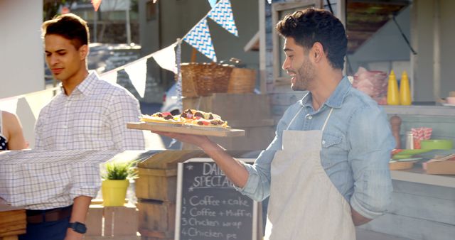 Man serving food at outdoor market stand - Download Free Stock Images Pikwizard.com