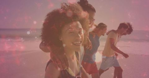 Carefree friends strolling at beach with vibrant sunset glow