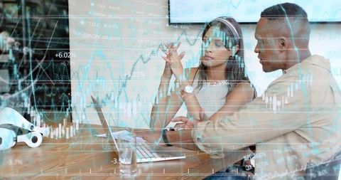 Business analysts collaborating over laptop with financial charts and candlestick data