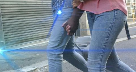 Couple Holding Hands with Suitcase on City Street