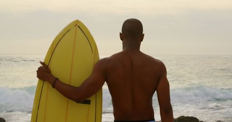 Surfer Holding Board Gazing at Ocean Horizon During Sunrise