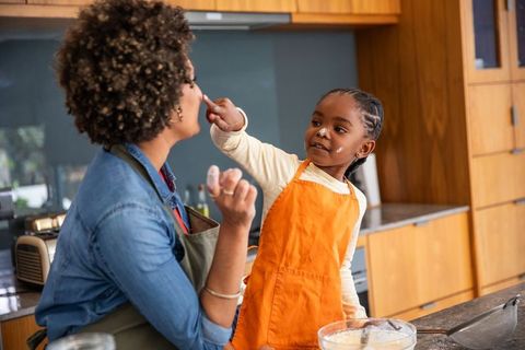 Mother and Daughter Playfully Baking Together in Kitchen