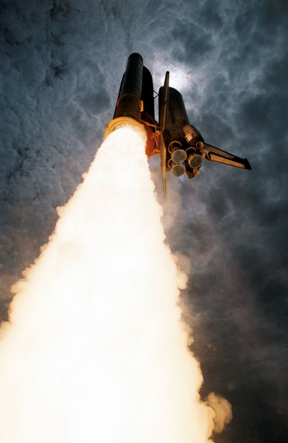 Space Shuttle Columbia launching on June 25, 1992, captured from a low angle with flames and smoke trailing behind. Columbia embarks on a scheduled 13-day mission supporting United States Microgravity Laboratory 1 research. Representing NASA's first Extended Duration Orbiter, the Shuttle carries five astronauts and two payload specialists working in shifts for microgravity experiments. Ideal for educational materials, space exploration articles, NASA mission retrospectives, and as powerful visuals in technology commercials or space-themed presentations.