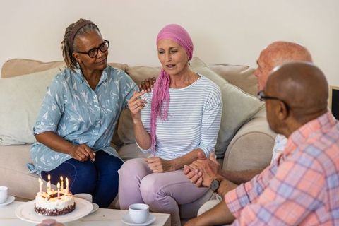 Diverse Senior Friends Celebrating Birthday with Cake in Living Room
