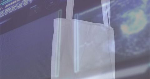 Hanging white canvas tote bag against futuristic neon display with cyan glow and nebula