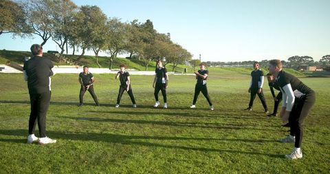 Sports team practicing under coach guidance on field