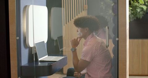 Businessman working in modern office enclosed private booth