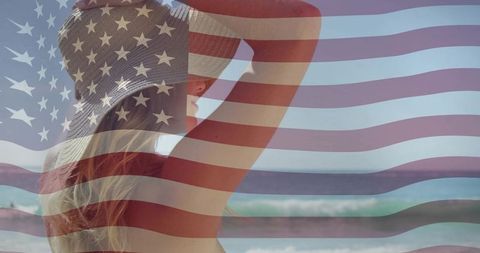 Woman watching ocean waves at beach with american flag overlay for patriotic summer