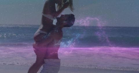 Couple carrying woman on ocean beach at sunset with pink nebula overlay for dreamy romance