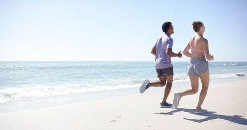 Couple Jogging Peacefully on Sunny Beach with Ocean Waves