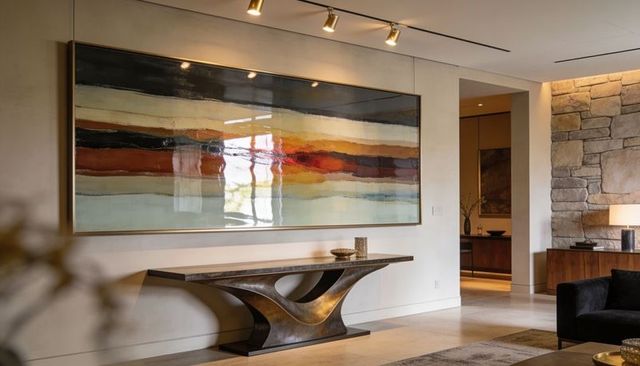 Contemporary foyer with large abstract painting, sculptural bronze console and track lighting