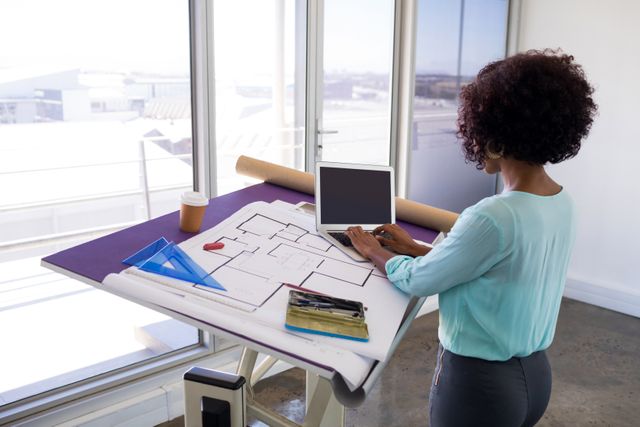 Female architect working over laptop in office