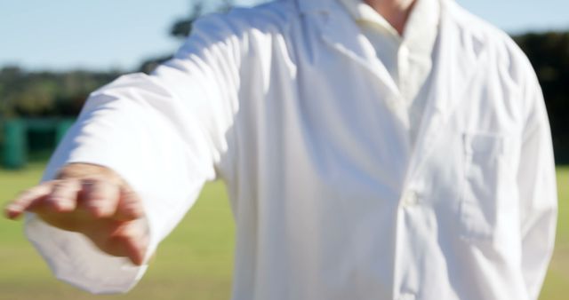Scientist outdoors in a field wearing a white lab coat extending hand. Ideal for themes of scientific work, nature research, outdoor studies, and professional interaction.