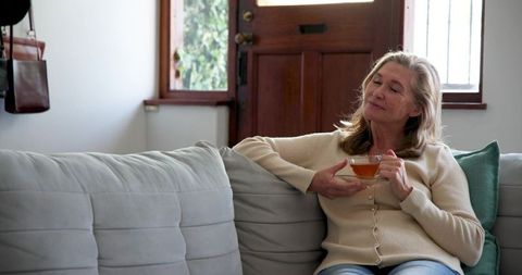 Senior Woman Relaxes in Calm Home Atmosphere Sipping Tea
