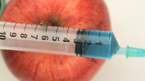 Injection into Apple Symbolizing Genetic Modification