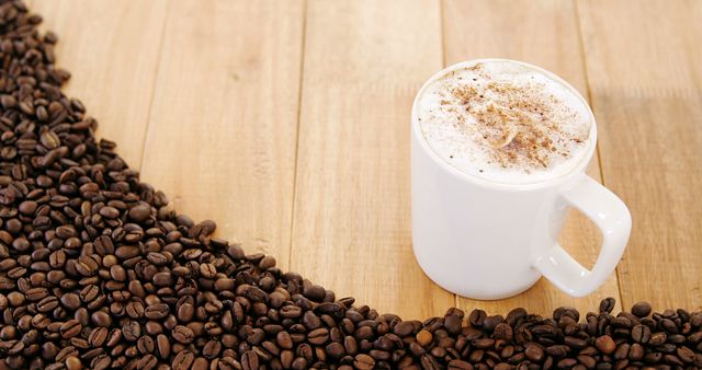 White Mug Filled with Foamy Coffee Surrounded by Coffee Beans on Wooden Table - Download Free Stock Images Pikwizard.com