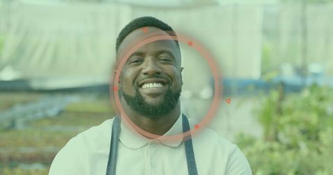 Smiling Gardener in Greenhouse with Seedlings and Apron
