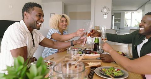 Friends Celebrating with Drinks at Dining Table